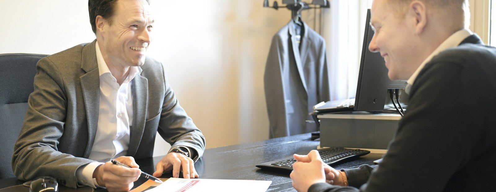 Two people discussing documents at a desk